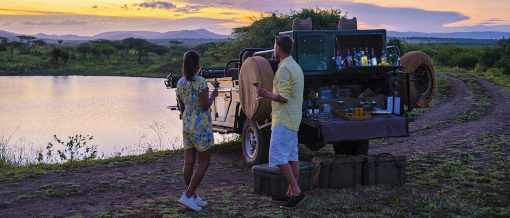 couple men and Asian woman on safari in South Africa, luxury safari car game drive South Africa